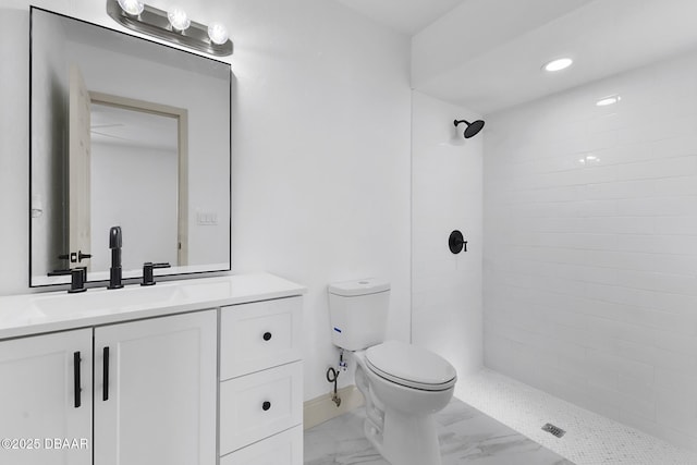 bathroom with vanity, baseboards, tiled shower, toilet, and marble finish floor