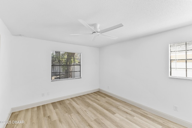 empty room with light wood-type flooring, baseboards, a textured ceiling, and a ceiling fan