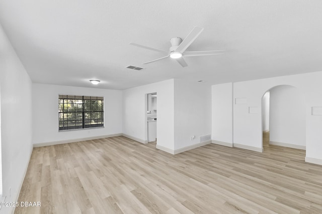 spare room featuring light wood-style flooring, visible vents, arched walkways, and ceiling fan