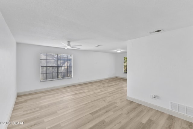 spare room with visible vents, ceiling fan, baseboards, and wood finished floors