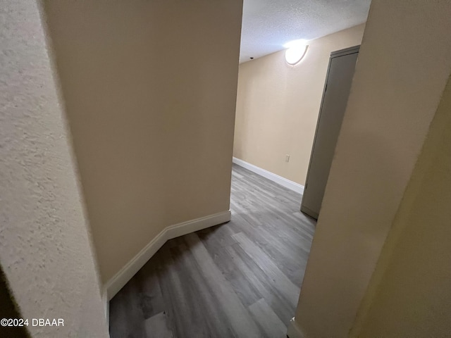 unfurnished room featuring light wood-type flooring and a textured ceiling