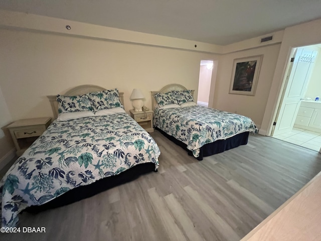 bedroom featuring connected bathroom and hardwood / wood-style floors