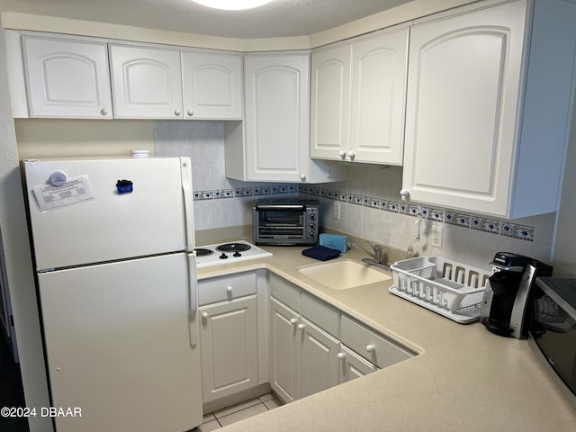 kitchen featuring white cabinets, white appliances, and sink