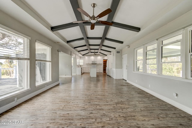 unfurnished living room with hardwood / wood-style flooring, ceiling fan, and vaulted ceiling with beams