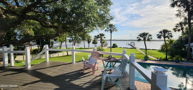 deck with a fenced in pool and a water view