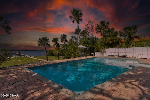 pool at dusk featuring a gazebo and a patio area