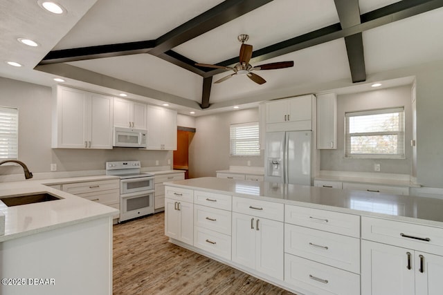 kitchen featuring lofted ceiling with beams, sink, white cabinets, and white appliances