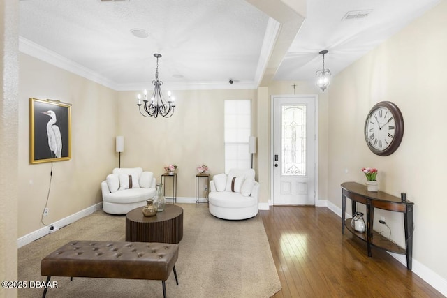 living area featuring an inviting chandelier, hardwood / wood-style flooring, and ornamental molding