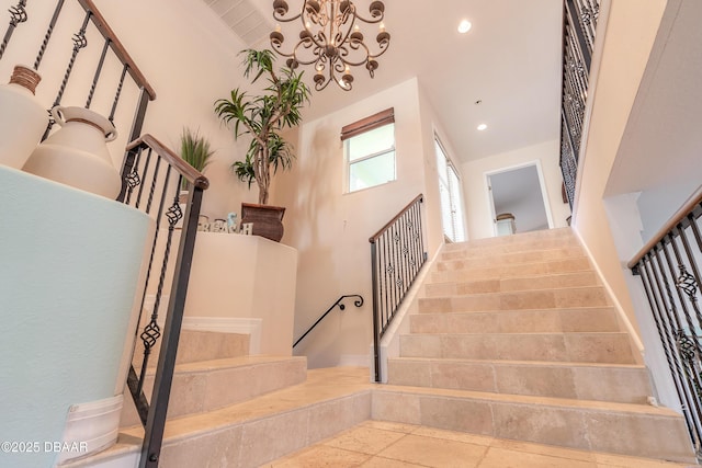 stairs with a notable chandelier and a towering ceiling