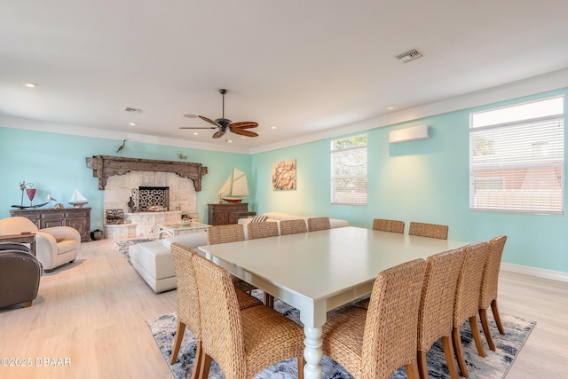 dining room with a wall mounted air conditioner, light wood-type flooring, ceiling fan, and ornamental molding