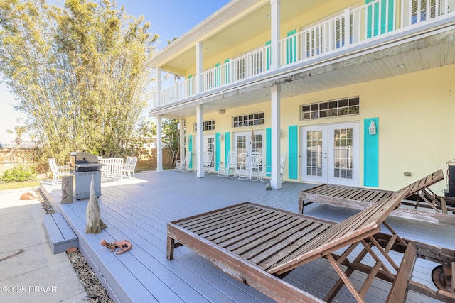 wooden deck with a grill and french doors