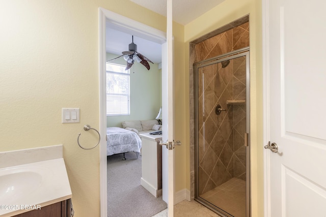 bathroom featuring ceiling fan, vanity, and an enclosed shower