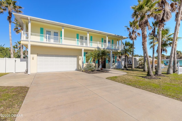 view of front facade featuring a balcony, a front yard, and a garage