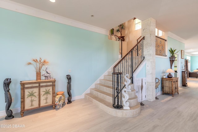 stairway featuring ornamental molding and hardwood / wood-style flooring