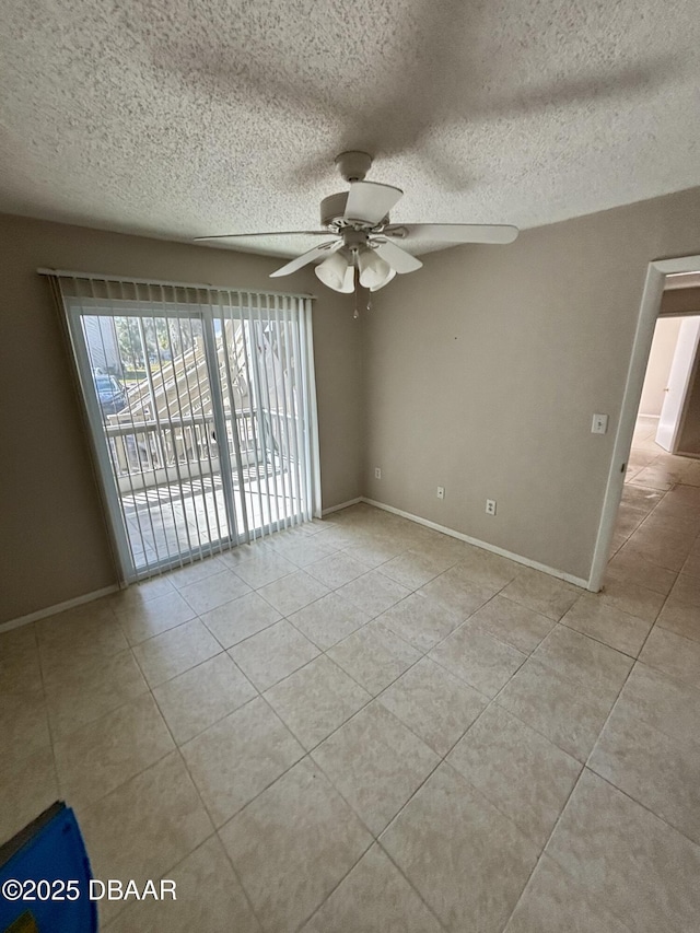 spare room with a textured ceiling, light tile patterned flooring, a ceiling fan, and baseboards