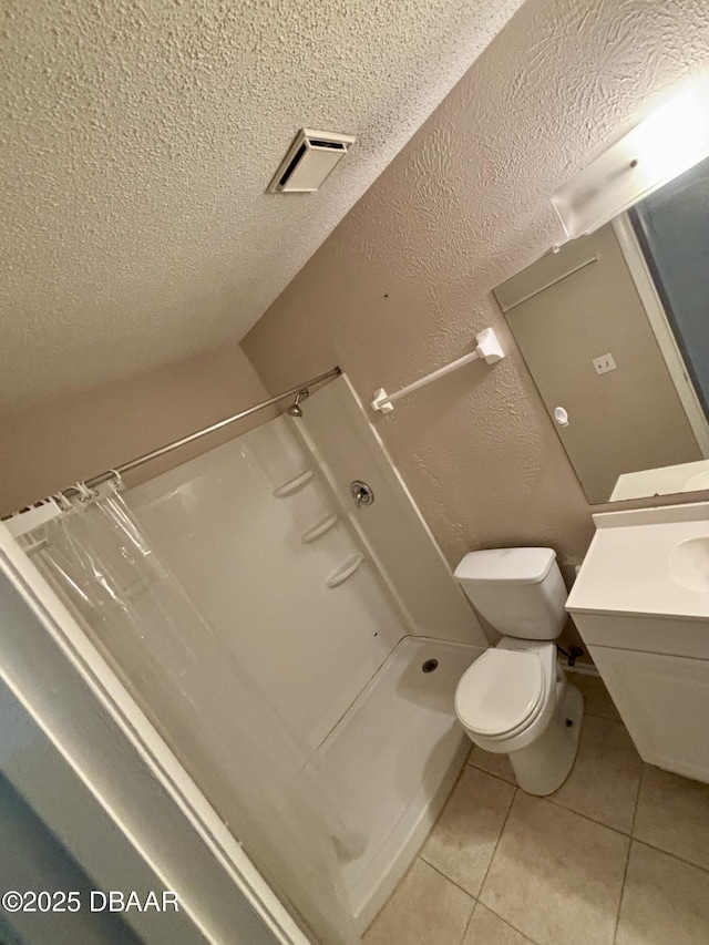 full bath featuring visible vents, a textured wall, toilet, tile patterned floors, and a textured ceiling