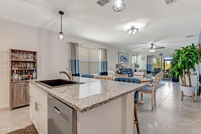1362 Cork Dr, Ormond Beach, FL 32174 - kitchen with stainless steel dishwasher, a sink, ceiling fan, open floor plan, and an island with sink
