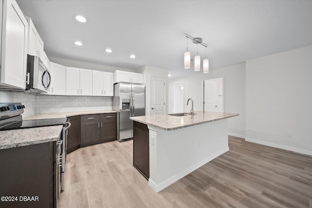 kitchen featuring light hardwood / wood-style floors, sink, appliances with stainless steel finishes, a kitchen island with sink, and white cabinets