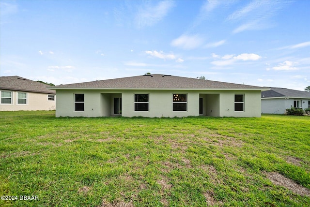 back of property with a lawn