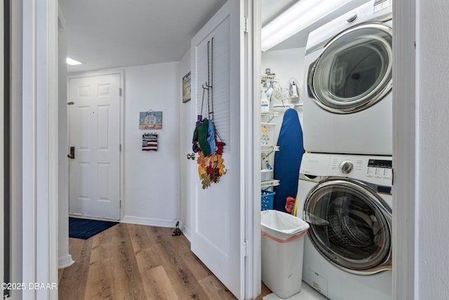 laundry room with stacked washer and dryer, light wood-type flooring, and laundry area