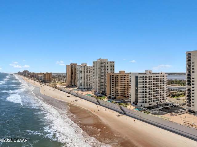 birds eye view of property featuring a water view, a beach view, and a city view