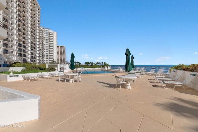 community pool featuring a water view and a patio