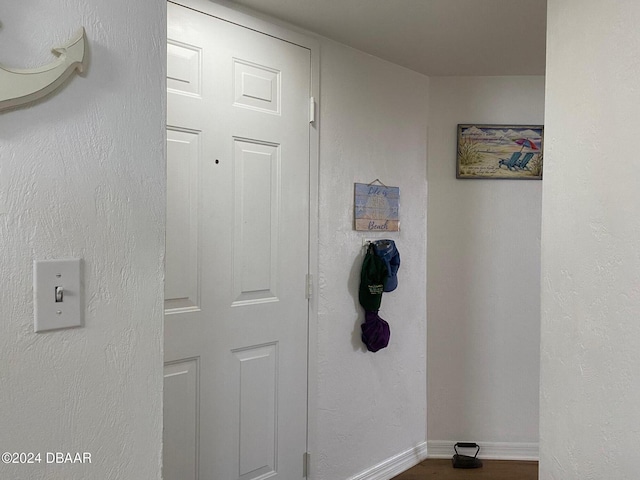 hallway featuring wood finished floors and baseboards