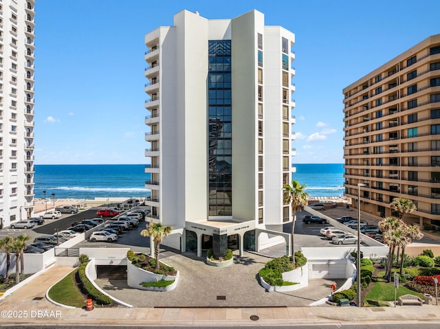 view of property featuring uncovered parking and a water view