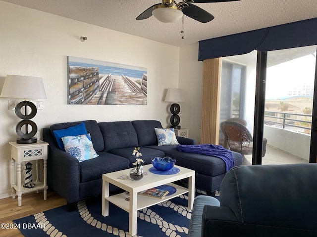 living room featuring ceiling fan, a textured ceiling, and wood finished floors