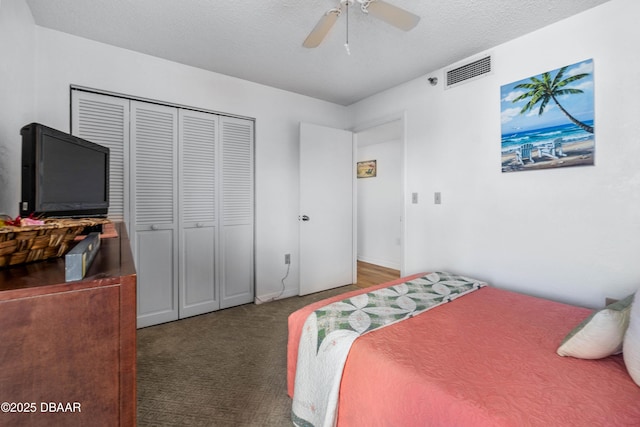 carpeted bedroom with a closet, visible vents, ceiling fan, and a textured ceiling