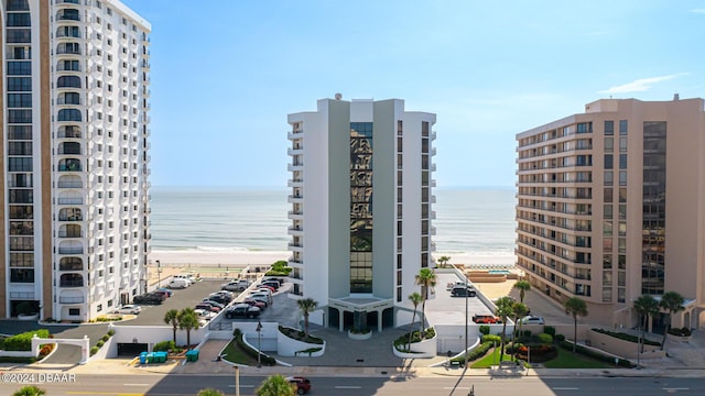 view of property with a water view and a beach view