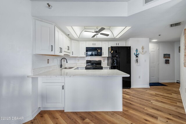 kitchen featuring kitchen peninsula, sink, white cabinets, and black appliances