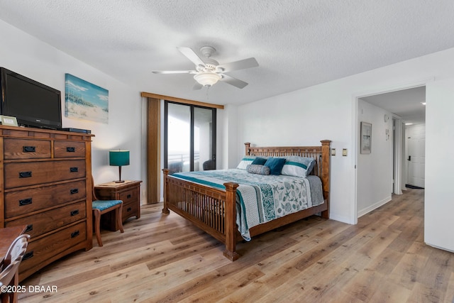 bedroom featuring baseboards, ceiling fan, light wood-style flooring, and a textured ceiling