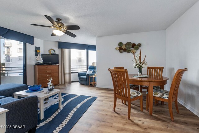 living area featuring a water view, light wood-type flooring, a textured ceiling, and a view of the beach