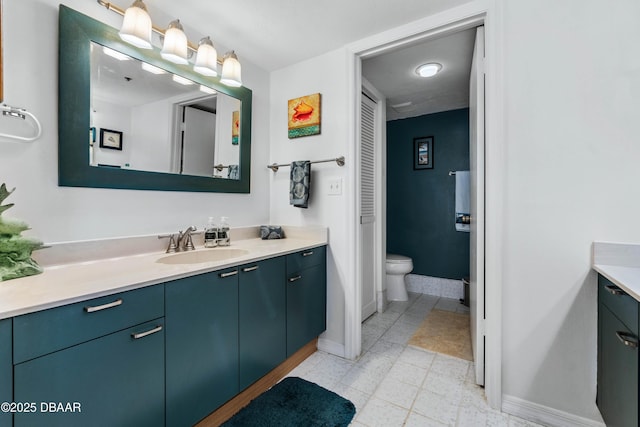 bathroom with a closet, baseboards, vanity, and toilet