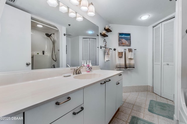 bathroom with a closet, vanity, and baseboards