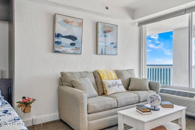 living room with radiator heating unit, a water view, and hardwood / wood-style flooring