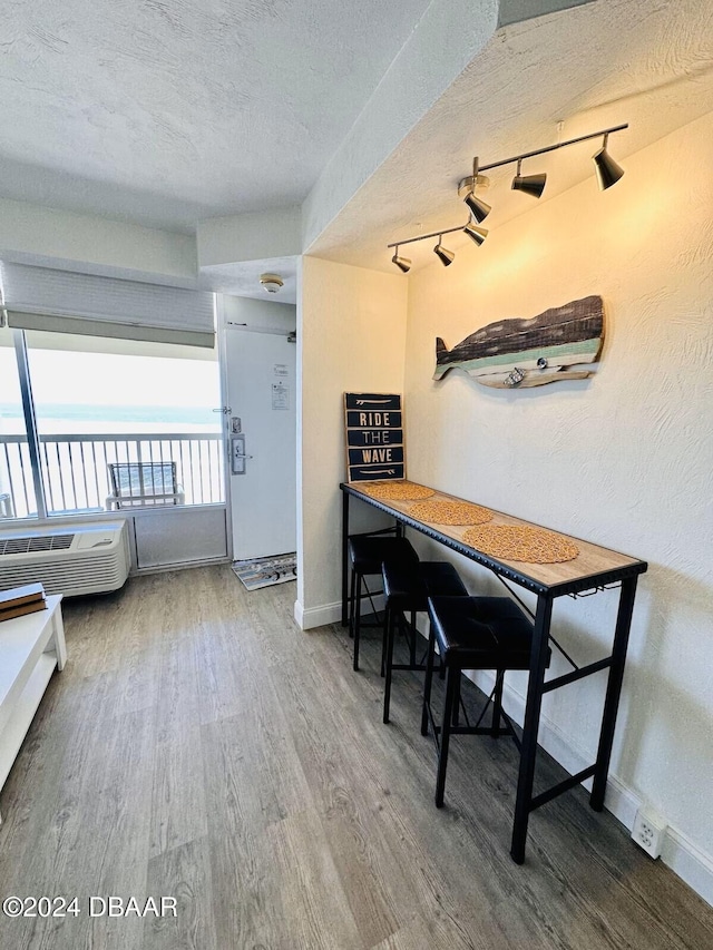 dining space featuring hardwood / wood-style floors, a water view, and a textured ceiling