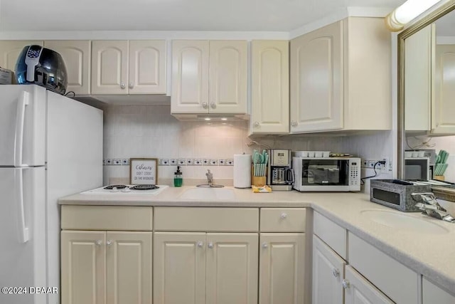 kitchen with decorative backsplash, sink, and white appliances