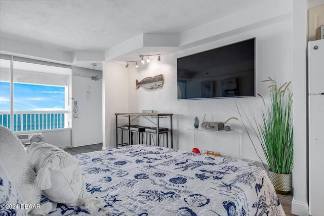 bedroom featuring wood-type flooring and a water view