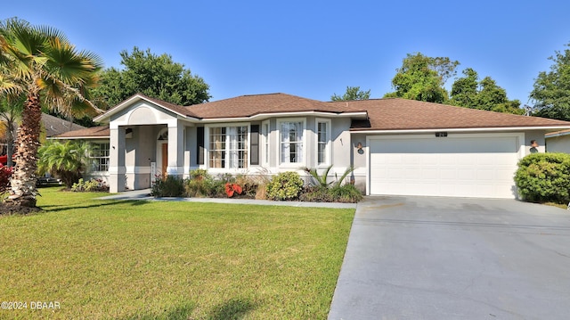 ranch-style house with a garage, stucco siding, concrete driveway, and a front yard