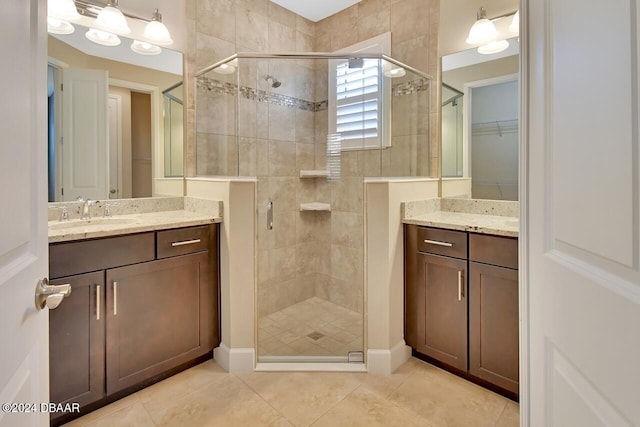 bathroom featuring tile patterned flooring, vanity, and a shower with door