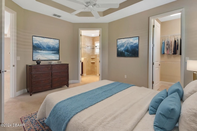 carpeted bedroom featuring a walk in closet, connected bathroom, a closet, and ceiling fan