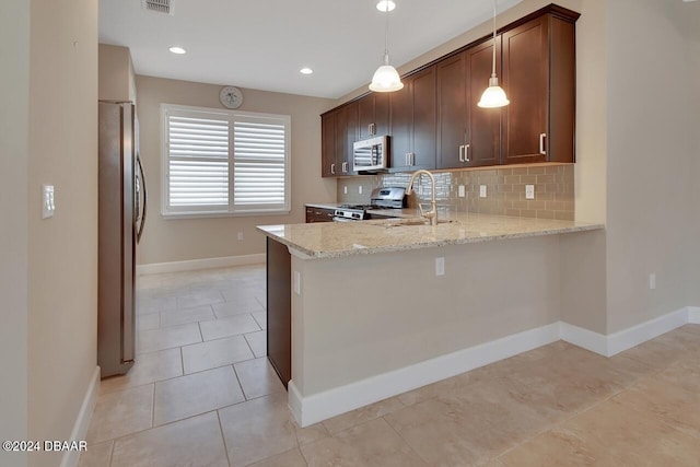 kitchen with hanging light fixtures, light stone countertops, tasteful backsplash, kitchen peninsula, and stainless steel appliances