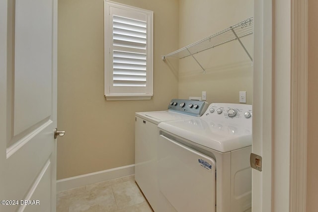 clothes washing area featuring light tile patterned floors and washing machine and clothes dryer