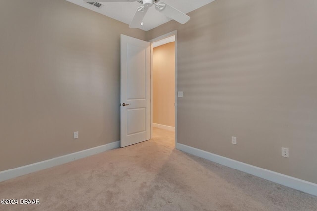 carpeted spare room with ceiling fan