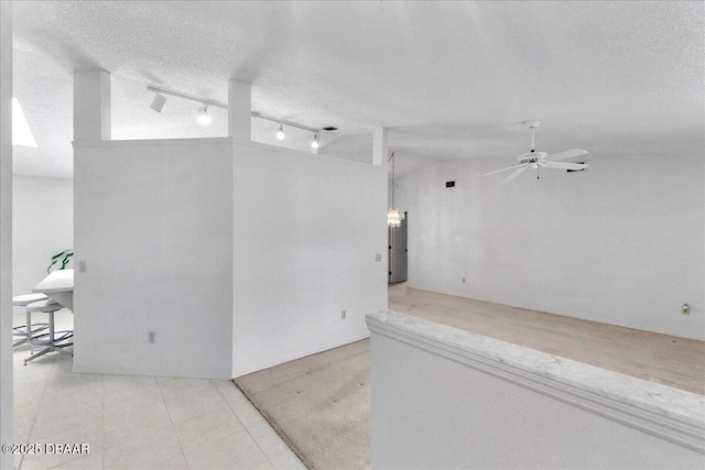 744 Hawks Ridge Rd, Port Orange, FL 32127 - tiled empty room with rail lighting, vaulted ceiling, ceiling fan, and a textured ceiling