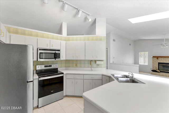744 Hawks Ridge Rd, Port Orange, FL 32127 - kitchen featuring stainless steel appliances, lofted ceiling, a peninsula, rail lighting, and ceiling fan
