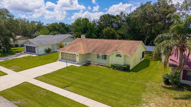 744 Hawks Ridge Rd, Port Orange, FL 32127 - view of front of property featuring an attached garage, a front lawn, driveway, and a chimney