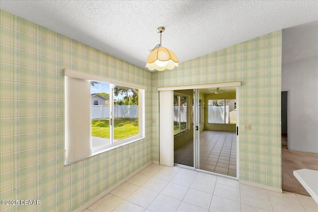 744 Hawks Ridge Rd, Port Orange, FL 32127 - unfurnished dining area with tile patterned floors, wallpapered walls, and a textured ceiling